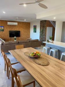 comedor y sala de estar con mesa de madera en 35 Bluefin Cove, en Exmouth