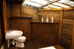 La salle de bains est pourvue de toilettes et d'un lavabo. dans l'établissement Maison d’hôtes bord de mer ia orana lodge, à Moorea