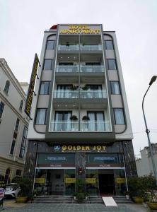 un edificio alto con un signo de alegría dorada en GOLDEN JOY HOTEL & APARTMENT, en Hai Phong