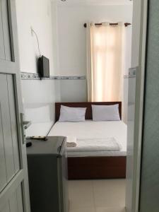 um pequeno quarto com uma cama e uma janela em Nam Dương 1 Hotel em Phan Rang-Tháp Chàm