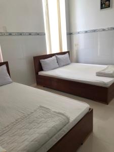 - deux lits assis l'un à côté de l'autre dans une pièce dans l'établissement Nam Dương 1 Hotel, à Phan Rang