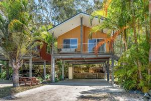 a house with a balcony and palm trees at BIG4 Tasman Holiday Parks - Nambucca Heads in Nambucca Heads