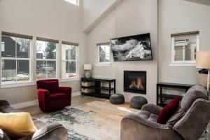a living room with two chairs and a fireplace at Southbridge Cottage: Cozy and Modern Home in Bozeman