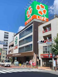 un grand bâtiment avec une enseigne au sommet dans l'établissement 201.Near Ueno Park/3min train St.Easx access, à Tokyo