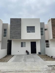a large white building with a black door at Casa santeli miramar in Ciudad Madero