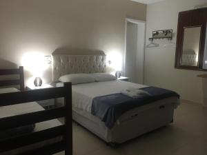 1 dormitorio con 1 cama con 2 lámparas y espejo en Pousada dos Franceses, en São Paulo