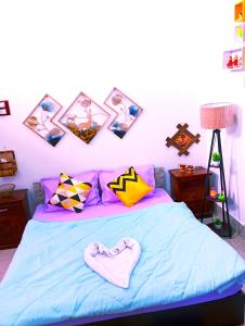 Un dormitorio con una cama azul con cuadros en la pared en JDreamland Homestay, en Jorhāt