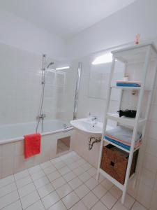 a white bathroom with a sink and a shower at Große Ferienwohnung Burgenland in Eisenstadt