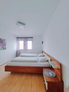 Große Ferienwohnung Burgenland في آيزنشتات: سرير كبير في غرفة مع أرضية خشبية