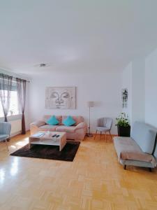 ein Wohnzimmer mit einem Sofa und einem Tisch in der Unterkunft Große Ferienwohnung Burgenland in Eisenstadt