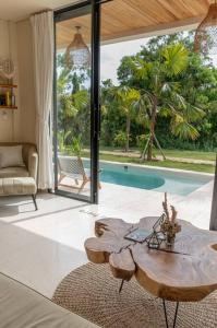 a living room with a table and a pool at Unique Tropical Villa in Uluwatu in Uluwatu