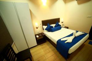 a hotel room with a bed with blue pillows at SAPPHIRE INN in Puducherry