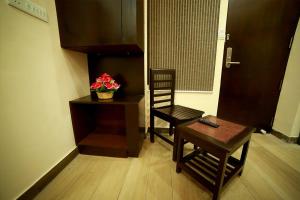 a living room with a table and a chair and a table and a chair at SAPPHIRE INN in Puducherry