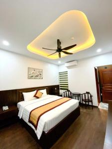a bedroom with a bed with a ceiling fan at Sunstar Hotel in Ha Long