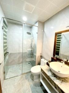 a bathroom with a shower and a toilet and a sink at Sunstar Hotel in Ha Long