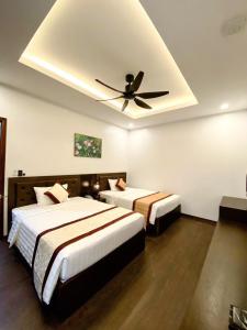 2 camas en una habitación de hotel con ventilador de techo en Sunstar Hotel, en Ha Long
