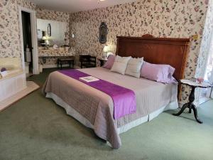 a bedroom with a large bed with purple sheets at Evening Shade Inn in Eureka Springs