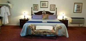 1 dormitorio con 1 cama con silla y 2 lámparas en Evening Shade Inn, en Eureka Springs