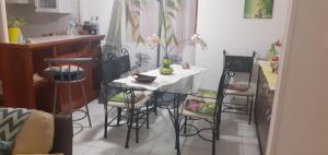 kuchnia ze stołem i krzesłami w pokoju w obiekcie Le p'tit nid cocodydy w mieście Baillif
