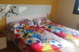 Dormitorio con cama de fútbol y edredón colorido en Chalet en Asturias, en Gijón