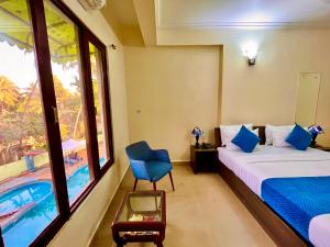 a hotel room with a bed and a swimming pool at Hotel The Golden Shivam Resort - Big Swimming Pool Resort In Goa in Goa