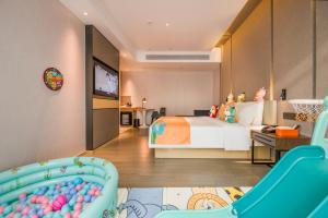 Habitación infantil con cama y TV en Atour Hotel Dongguan Humen Avenue, en Dongguan