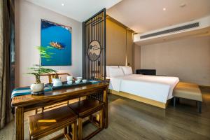 a hotel room with a bed and a desk with a table sidx sidx at Atour Hotel Dongguan Humen Avenue in Dongguan