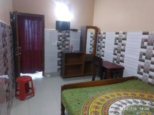 a bedroom with a bed and a desk and a mirror at Hotel Milan Guest House Digha - Couple Friendly in Digha