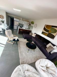 uma sala de estar com um sofá azul e mesas em Mountain View Escape em Frankton