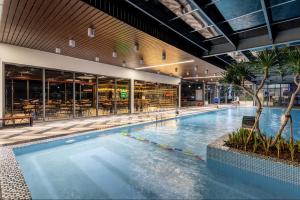 a large swimming pool in a building with a restaurant at M Continental by Mandala Bac Giang in Bắc Giang