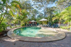 a large swimming pool with a patio and trees at BIG4 Tasman Holiday Parks - Nambucca Heads in Nambucca Heads