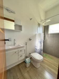 uma casa de banho com um WC, um lavatório e um chuveiro em N02 Kitnet em Jacutinga em Jacutinga