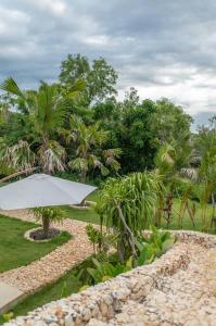 a white umbrella in a garden with trees at Stylish Tropical Villa in Uluwatu in Uluwatu