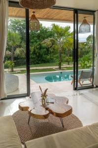 a living room with a table and a pool at Stylish Tropical Villa in Uluwatu in Uluwatu