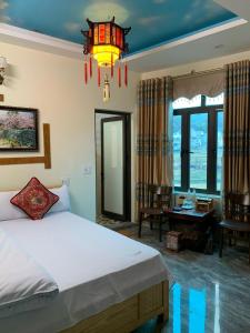 a bedroom with a bed and a chandelier at Mai's Homestay Dong Van in Dồng Văn +28 photos