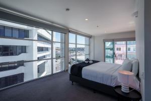 a bedroom with a bed and a large window at Chic Princes Wharf Studio - City View - Parking in Auckland