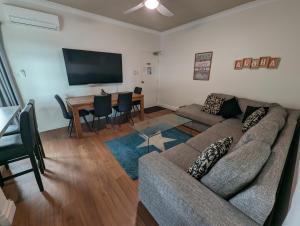 ein Wohnzimmer mit einem Sofa und einem Tisch in der Unterkunft Aloha Beachside in Forster