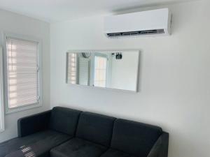 Una sala de estar con un sofá y un espejo. en Points, en Guayama 12 fotos más