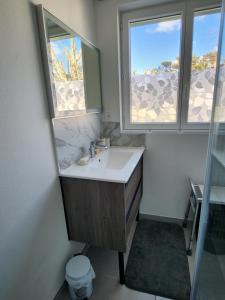 Appartement vue mer في سان-جورج-دي-ديدون: حمام مع حوض ونوافذ