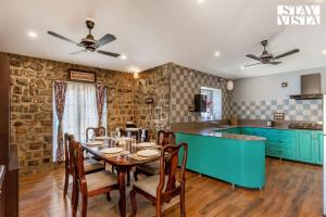 uma cozinha e sala de jantar com mesa e cadeiras em The Enchanted Forest with ATV Bike, Pet Friendly at Jim Corbett by StayVista em Kota Bāgh