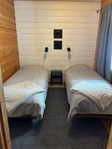 a room with two beds in a room with a wall at Kodikas loma-asunto Tahkon ytimestä in Tahkovuori