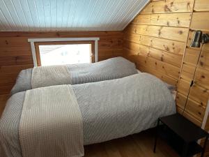 a bedroom with a bed in a wooden room at Kodikas loma-asunto Tahkon ytimestä in Tahkovuori