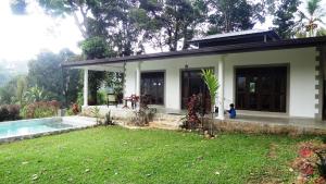 una casa con un patio delante de ella en Monkey manor villa, Strathisla Tea Estate Bungalow en Matale