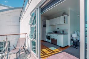 a balcony with a table and a chair and a kitchen at Chic Princes Wharf Studio - City View - Parking in Auckland