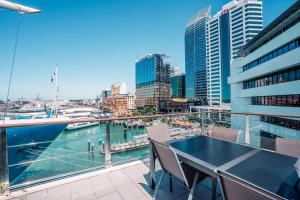 a balcony with a table and chairs and a view of the city at Chic Princes Wharf Studio - City View - Parking in Auckland