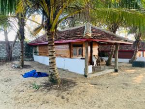 uma casa na praia com uma palmeira em Shim Beach Resort em Arugam Bay