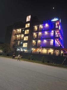 un bâtiment avec des lumières bleues allumées la nuit dans l'établissement Hotel Red York By Byob Hotels, à Noida