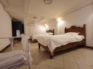 ルアンパバーンにあるFortunate angle guesthouse 乐居のベッドルーム1室(ベッド2台、テーブル、椅子付)