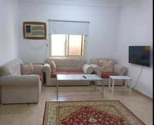 Soma Suites في المدينة المنورة: غرفة معيشة مع أريكة وطاولة