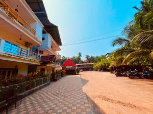 a cobblestone street next to a building with palm trees at The Four Season Hotel & Cottage, Goa in Candolim